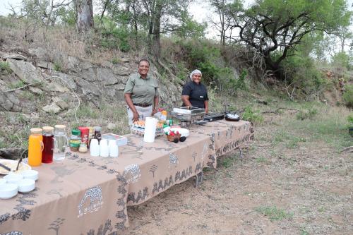 two men standing next to a table with food on it at Masodini Game Lodge in Hoedspruit