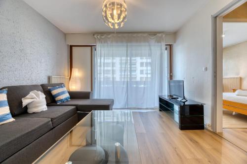 un salon avec un canapé et une télévision dans l'établissement Maxime île Lacroix, à Rouen