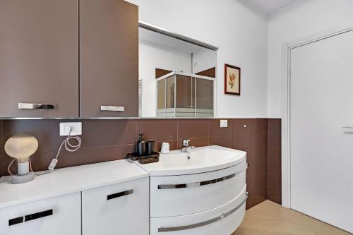 a bathroom with a white sink and a mirror at Art&Comfort Apartment - 2 passi dalla Stazione in Paderno Dugnano