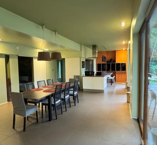 a dining room and kitchen with a table and chairs at Dom nad Jeziorem Gwiazda in Wójcin