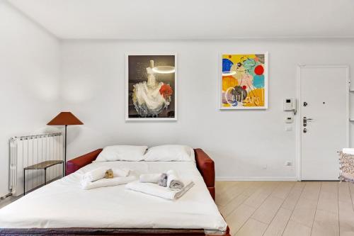 a white bedroom with a bed and a painting at Art&Comfort Apartment - 2 passi dalla Stazione in Paderno Dugnano