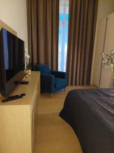 a room with a bed and a tv and a couch at Zepterme Apartman 012 in Vrnjačka Banja