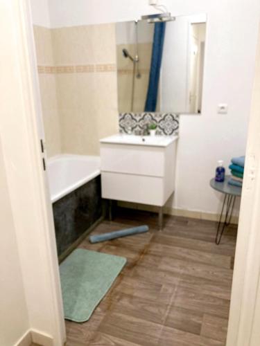 une salle de bain avec un lavabo, une baignoire et un miroir dans l'établissement 7 people, 5 MINUTES Paris, Metro, Parking, à Saint-Denis
