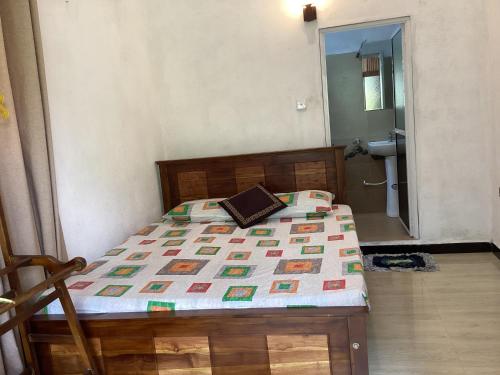a bedroom with a bed and a bathroom with a sink at Nila Villa in Galle