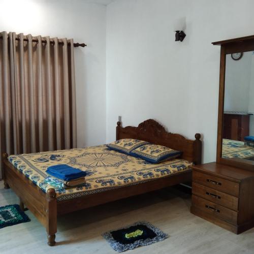 a bedroom with a bed and a mirror and a radiator at Nila Villa in Galle