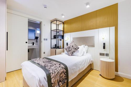 a bedroom with a large bed with white sheets at Rosemay Hotel near London Heathrow Airport in Hayes