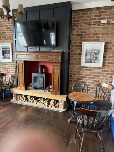 a living room with a fireplace with a tv above it at The Holystone Bar and Restaurant in Newcastle upon Tyne