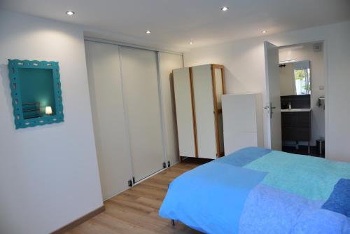 ein Schlafzimmer mit einem Bett und einem Spiegel an der Wand in der Unterkunft Chez Denis et Isabelle in Pornic