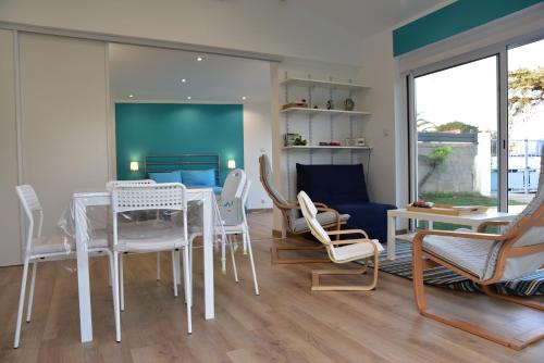 une salle à manger avec une table et des chaises blanches dans l'établissement Chez Denis et Isabelle, à Pornic