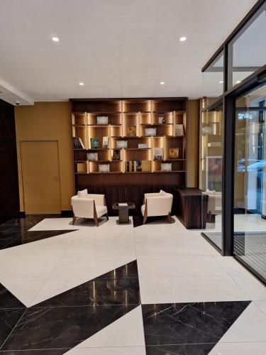 a lobby with two chairs and a book shelf at Zepterme Apartman 012 in Vrnjačka Banja