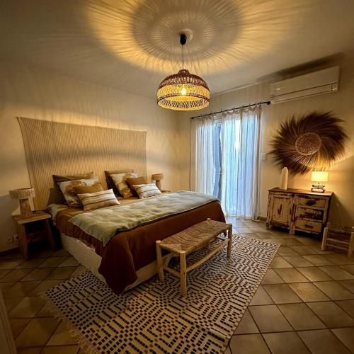 une chambre avec un grand lit et un lustre dans l'établissement Apartment St Remy de Provence, à Saint-Rémy-de-Provence