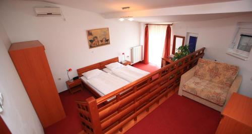 a bedroom with a large bed and a chair at Hotel Orion in Ivanec