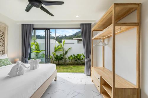 a bedroom with a bed and a large window at Villa Gabriela Garden view - Included Airport pick up in Nathon Bay