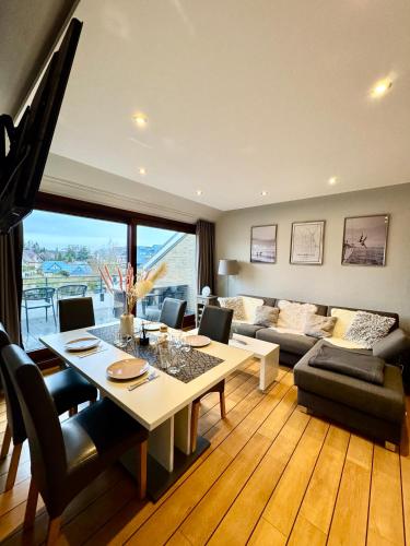 a living room with a table and a couch at Ferienwohnung Strandperle - nur 150m zum Strand in Scharbeutz