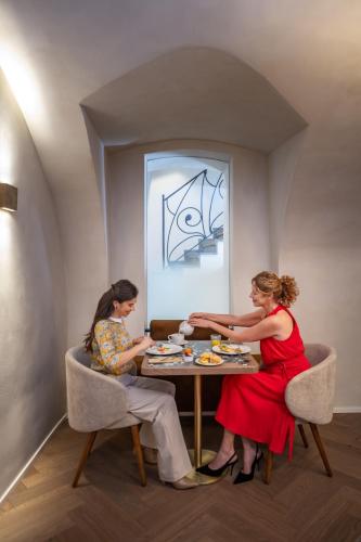 two women sitting at a table eating food at Hotel BOOKQUET in Prague
