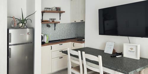 a kitchen with a refrigerator and a table with chairs at Nad Tunelom Studio hosted by family in Zagreb