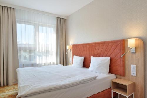 a bed in a hotel room with a large window at Bel mare aqua 2 Aquapark in Międzyzdroje