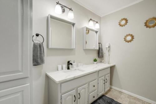 a white bathroom with a sink and a mirror at Spectacular 4BR 2,5BA Holiday Home with Pool and Grill in Carrollton