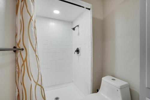 a white bathroom with a shower and a toilet at Spectacular 4BR 2,5BA Holiday Home with Pool and Grill in Carrollton