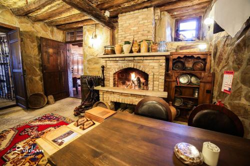 a living room with a stone fireplace and a table at Sillehan Boutique Hotel in Konya
