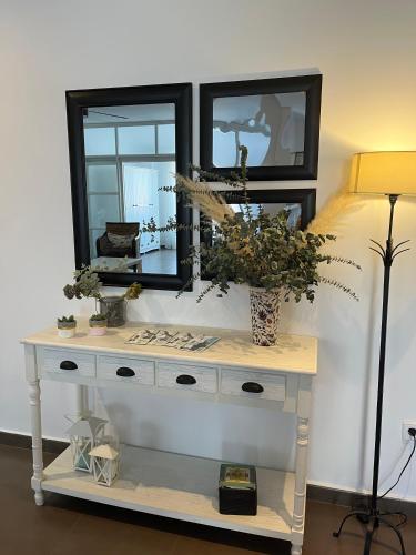 a white console table with a mirror and a lamp at Apartamento JALAMA 1C in Moraleja