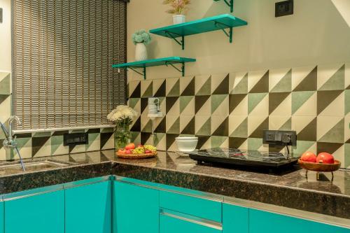 a kitchen with a counter with blue cabinets and a sink at G S Stay, 2BHK Luxury apartment Baga, Arpora, Goa in Arpora