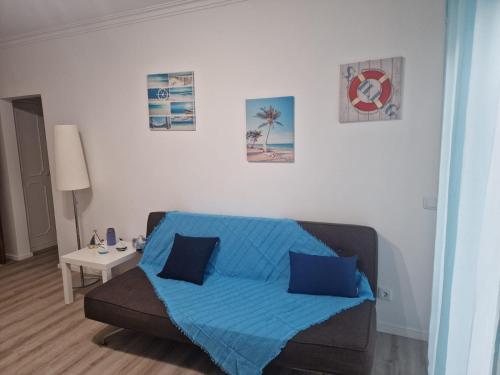 a living room with a couch with a blue blanket at Apartamento em Quarteira in Quarteira