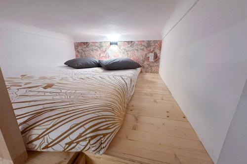 une chambre avec un lit avec deux oreillers dessus dans l'établissement CLEMENCEAU 2 Studio Confortable Clim et Dressing Proche Gare, à Nice