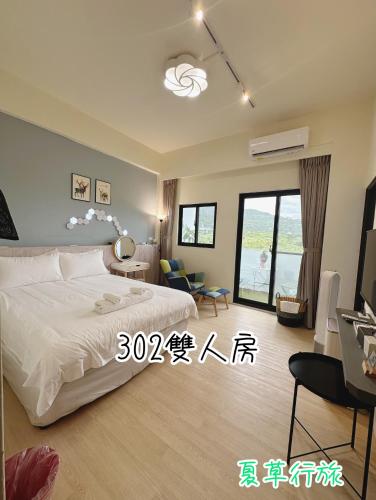 a bedroom with a bed and a living room at Summer Grass B&B 台東縣民宿1729號 in Taitung City