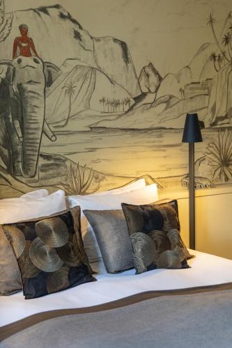 a bedroom with a mural of an elephant on the wall at La Maison Pavie in Dinan