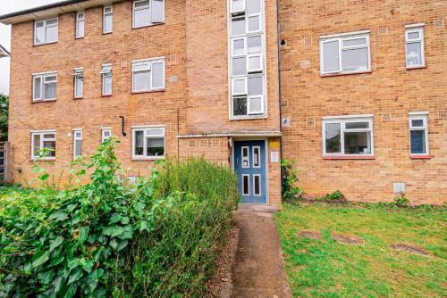 a brick building with a blue door in front of it at Stylish 2-Bed Flat on Banbury Road in Oxford