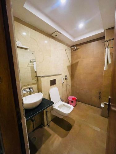 a bathroom with a white toilet and a sink at Hotel Aghore Shaktipeeth in Narendranagar