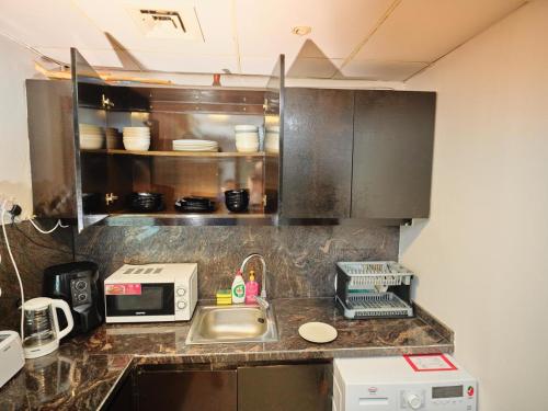 a kitchen with a sink and a microwave at Wonderful 1BD With Full Marina View in Dubai