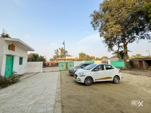 a white car parked next to two parked cars at Raghuveer Sadan, Near Ram Mandir -10 Min Walk in Ayodhya