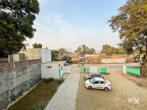 two cars parked in a parking lot next to a street at Raghuveer Sadan, Near Ram Mandir -10 Min Walk in Ayodhya