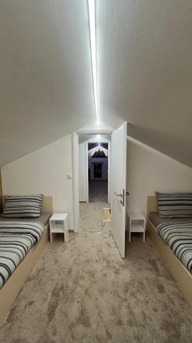 an empty room with two beds and a hallway at Apartmani Kiki 2 in Pale