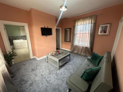 a living room with a couch and a table at Cozy flat by Birmingham Canals & City Centre in Birmingham