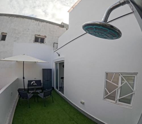 大加那利岛拉斯帕尔马斯Violeta Suite的户外庭院配有桌子和遮阳伞。