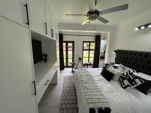 a bedroom with a large bed and a ceiling fan at The Bryanston Boutique in Johannesburg
