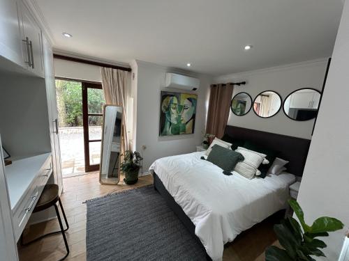约翰内斯堡The Bryanston Boutique的卧室配有一张白色大床和镜子