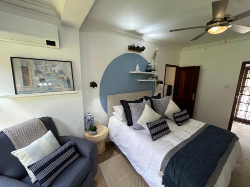 约翰内斯堡The Bryanston Boutique的一间卧室，有一张床和一张蓝色沙发