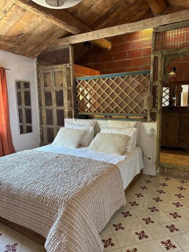 une chambre avec un lit et un mur de briques dans l'établissement Petit Mas de ville, à Saint-Rémy-de-Provence