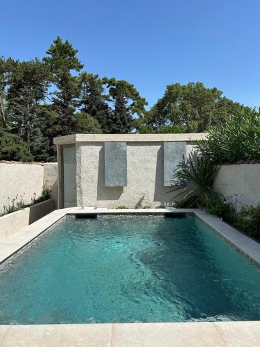 une petite piscine dans une cour arborée dans l'établissement Petit Mas de ville, à Saint-Rémy-de-Provence