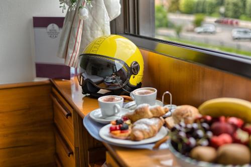 a table with a helmet and a plate of food at Hotel Valpolicella International in San Pietro in Cariano