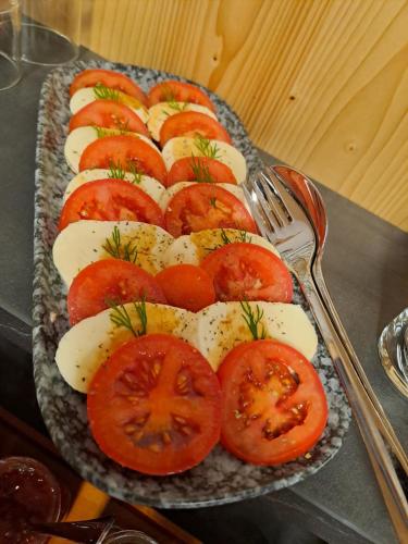 a plate of tomatoes and cheese on a table at Pension Alpenfeeling in Pfronten