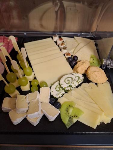 a tray with different types of cheese and grapes at Pension Alpenfeeling in Pfronten