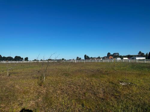 a field of grass with a fence in the background at Cabañas quilquico spa in Quilquico