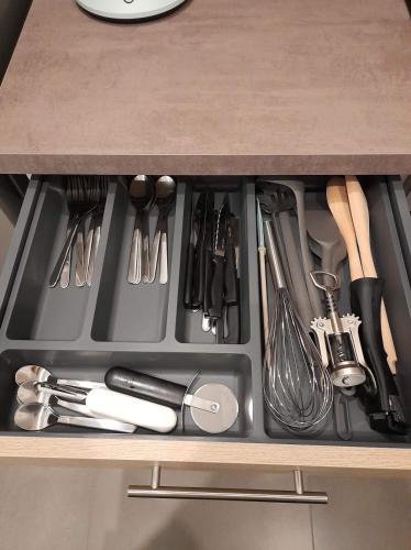 un tiroir rempli d'ustensiles sur un comptoir de cuisine dans l'établissement T2 Spacieux et Confortable, à Mulhouse