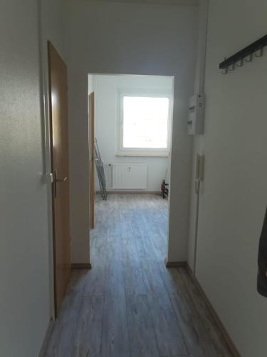 Habitación vacía con ventana y suelo de madera. en 2 Bett Monteurwohnung in Zeithain, en Zeithain