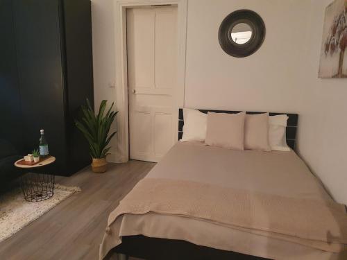 une chambre avec un grand lit avec des oreillers blancs dans l'établissement Modern and cozy studio 2 minutes from Porte d'Orléans, à Paris